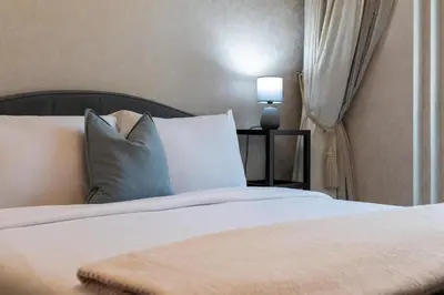 a bed with white sheets and pillows in a room at Lux BnB I Souk Al Bahar I Burj Khalifa Views in Dubai