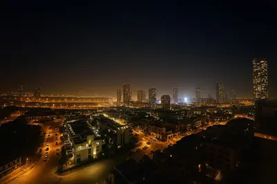 a city lit up at night with tall buildings at Stylish Studio For Two in Dubai