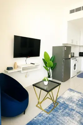 a living room with a blue chair and a table at Stylish Studio For Two in Dubai