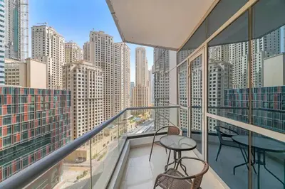 a balcony with two chairs and a table and some buildings at StoneTree - Elegant 1BR with Amazing Building Facilities in Dubai
