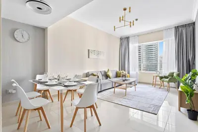 a white living room with a table and chairs at StoneTree - Sit Back, Relax and Your New View Awaits in Dubai