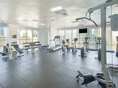 a gym with a lot of treadmills and machines at StoneTree - Sit Back, Relax and Your New View Awaits in Dubai