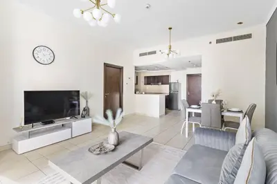 a living room with a large television and a table at StoneTree - Elegant 1BR in Famous Location in Dubai