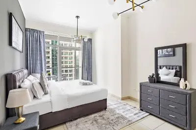 a bedroom with a large bed and a window at StoneTree - Elegant 1BR in Famous Location in Dubai
