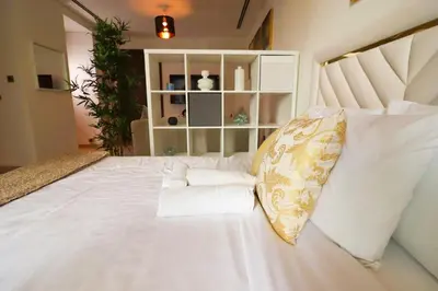 a bedroom with a white bed with towels on it at Celestial Ambiance Studio in Dubai