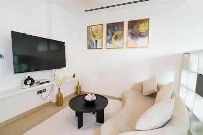 a living room with a couch and a tv at Celestial Ambiance Studio in Dubai