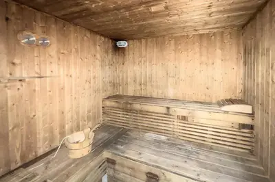 an empty wooden sauna with a bucket in it at GuestReady - Exquisite stay near Dubai Canal in Dubai
