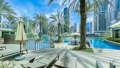 a resort with a pool and palm trees at StoneTree - Stylish fully-furnished 1 BR in Dubai