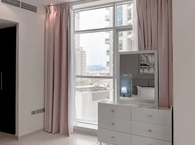 a bedroom with a large window and a dresser with a dresser at StoneTree - Amazing View - Modern 1BR in Dubai