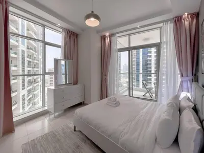 a bedroom with a bed and large windows at StoneTree - Amazing View - Modern 1BR in Dubai