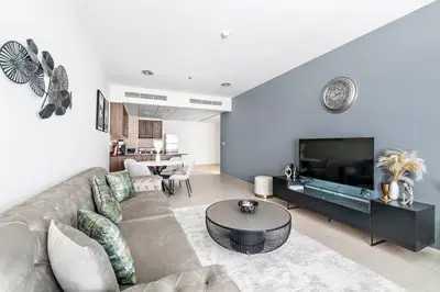 a living room with a couch and a television at StoneTree - High Floor Furnished 1 BR in Dubai