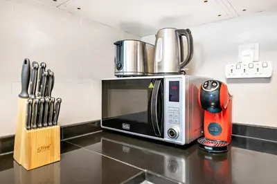 a microwave sitting on top of a kitchen counter at StoneTree - Furnished 1BR with Stunning View in Dubai