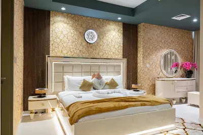 a bedroom with a large white bed with gold sheets at Luxury Apartments with Rooftop Pool in Paramount Hotel Midtown By Aurora in Dubai