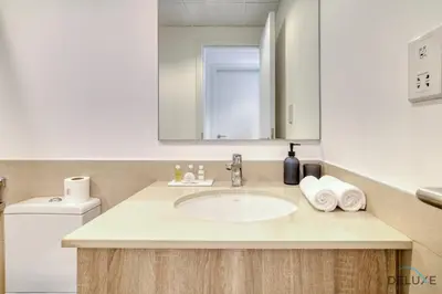 a bathroom with a sink and a mirror at Immaculate 1BR at UNA Town Square Dubailand by Deluxe Holiday Homes in Dubai
