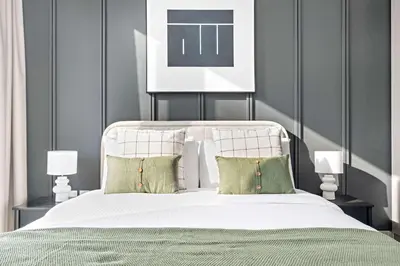 a bedroom with a large white bed with green pillows at Silkhaus classical 1BDR in Opera District in Dubai