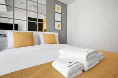 a pile of towels sitting on top of a bed at StoneTree - Modern Furnished Studio in Dubai