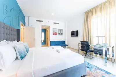 a bedroom with a large bed and a desk at Spacious Modern 1BR in Business Bay in Dubai