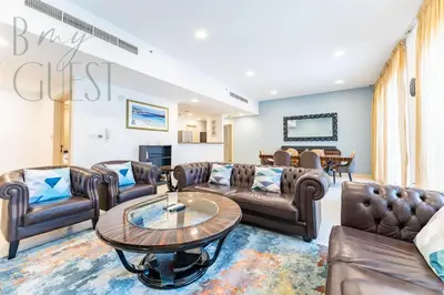a living room with leather furniture and a table at Spacious Modern 1BR in Business Bay in Dubai