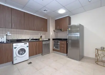 a kitchen with a dishwasher and a washer in it at StoneTree - Near Tram - Furnished 1BR in Dubai
