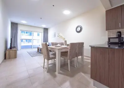 a kitchen and dining room with a table and chairs at StoneTree - Near Tram - Furnished 1BR in Dubai