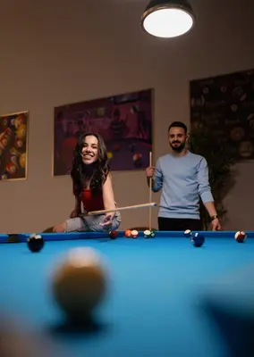 a man and a woman playing a game of pool at DAMAC Maison Aykon City Dubai in Dubai