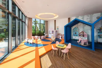 a room with a playroom with pink chairs and a room with a play room at DAMAC Maison Aykon City Dubai in Dubai