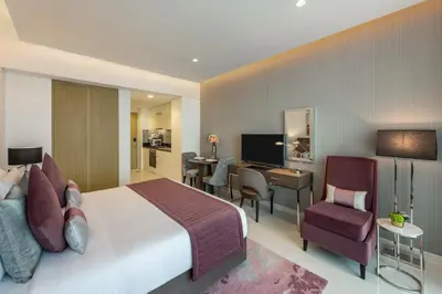 a hotel room with a large bed and a desk at DAMAC Maison Aykon City Dubai in Dubai