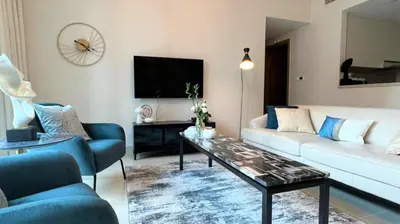 a living room with a white couch and a coffee table at Luxurious Creek Harbour Apt with Balcony & View in Dubai