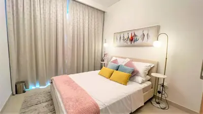 a bedroom with a bed with yellow and blue pillows at Luxurious Creek Harbour Apt with Balcony & View in Dubai