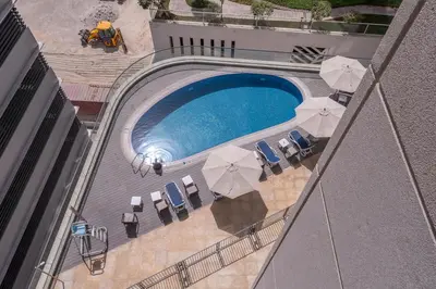 an overhead view of a swimming pool with chairs and umbrellas at Heaven Crest Vacation Homes Downtown - Studio and 1 Bedroom Suites 2 minute walk to Dubai Mall and Burj Khalifa in Dubai