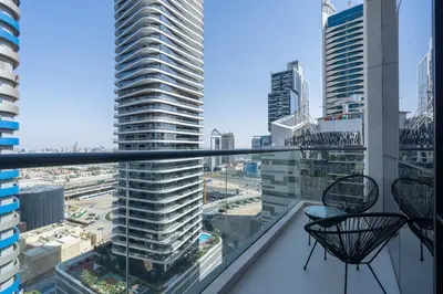 a balcony with two chairs and a view of a city at Heaven Crest Vacation Homes Downtown - Studio and 1 Bedroom Suites 2 minute walk to Dubai Mall and Burj Khalifa in Dubai