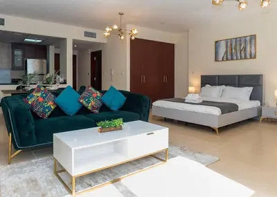 a living room with a couch and a bed at StoneTree - Studio Apartment Near The Beach in Dubai