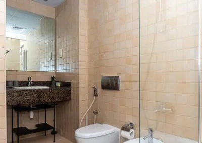 a bathroom with a toilet and a sink and a mirror at StoneTree - Studio Apartment Near The Beach in Dubai