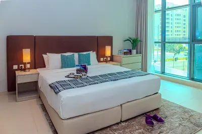 a bedroom with a large bed with purple shoes on the floor at Dream Inn - Seven Palm - Free Beach Access in Dubai