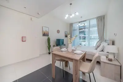 a living room with a table and a couch at StoneTree - Furnished Studio in Golf Promenade 3A in Dubai