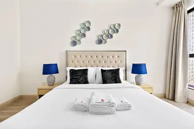 a bedroom with a white bed with two towels on it at StoneTree - Near Beach - Furnished 1BR with Partial Sea View in Dubai