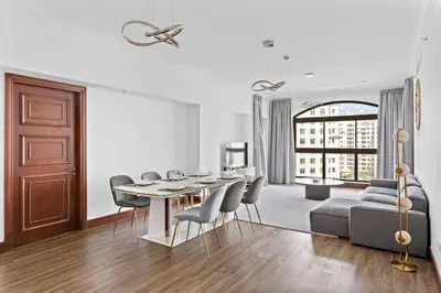 a living room with a table and chairs and a couch at StoneTree - 2 BR apartment in Golden Mile 6 Near Nakheel Mall in Dubai