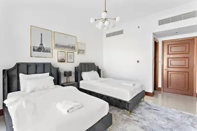 a bedroom with two beds and a brown door at StoneTree - 2 BR apartment in Golden Mile 6 Near Nakheel Mall in Dubai