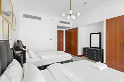 a room with two beds and a mirror at StoneTree - 2 BR apartment in Golden Mile 6 Near Nakheel Mall in Dubai