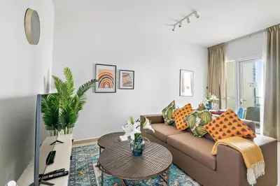 a living room with a couch and a table at StoneTree - Furnished 1 BR Apartment Near to Tram in Dubai