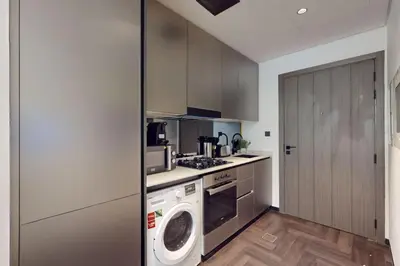 a kitchen with a washing machine and a washer at O Ten, Al Jaddaf - Neat Studio in Dubai