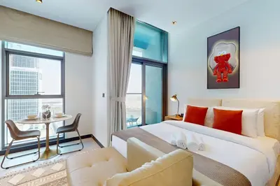 a bedroom with a large bed and a table and chair at 15 Northside Tower 1 - Elegant Studio in Dubai