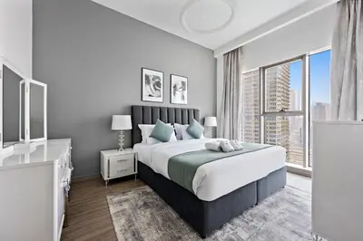 a bedroom with a large bed and a large window at StoneTree - New stylish 1 BR Apartment in JLT in Dubai
