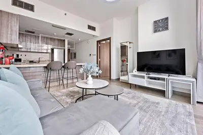 a living room with a couch and a kitchen at StoneTree - New stylish 1 BR Apartment in JLT in Dubai