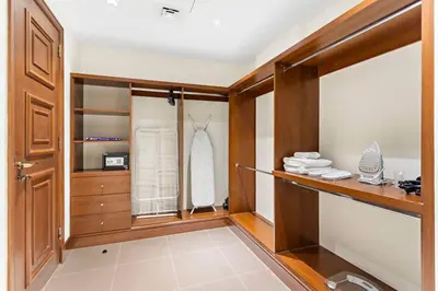 a bathroom with a closet with wooden cabinets and a mirror at StoneTree - Luxurious 2 BR Apartment in Palm Jumeirah in Dubai