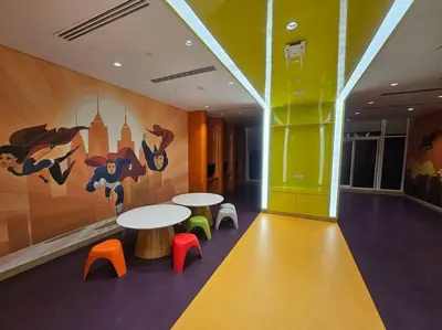a room with two tables and colored chairs and a mural at Luxury Business Bay Studio with breathtaking views. in Dubai