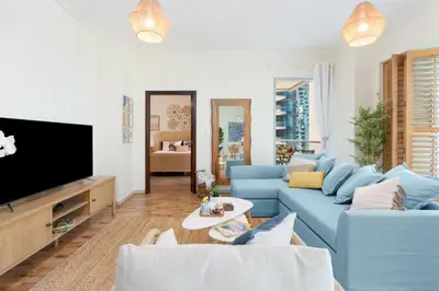 a living room with a blue couch and a tv at Boutique Apartment Sea Views - Dubai Marina in Dubai