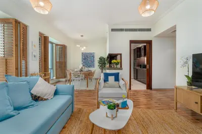 a living room with a blue couch and a table at Boutique Apartment Sea Views - Dubai Marina in Dubai