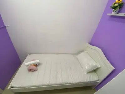 a small white bed in a room with flowers at Single Partition Room in Al Barsha 1 Near Mashreq Metro in Dubai