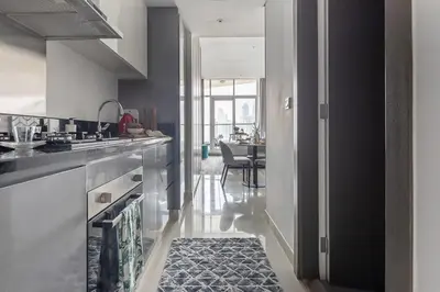 a kitchen with a sink and a table with a rug at Frank Porter - Damac Prive B in Dubai